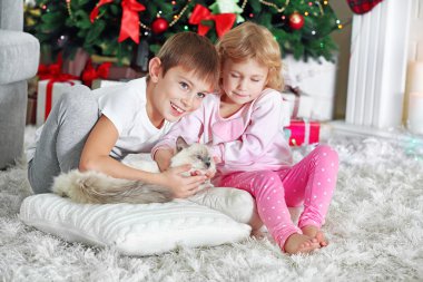 Komik çocuklar hediye kutuları ve arka plan üzerinde Noel ağacı ile