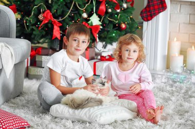 Komik çocuklar hediye kutuları ve arka plan üzerinde Noel ağacı ile