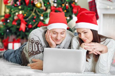 Mutlu aile ile Noel ağacı arka plan üstünde laptop