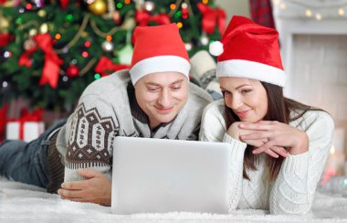 Mutlu aile ile Noel ağacı arka plan üstünde laptop