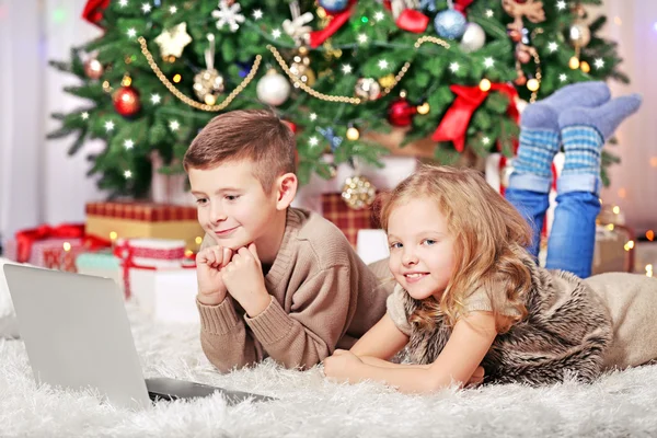 Ευτυχισμένα παιδιά με φορητό υπολογιστή στο δωμάτιο Χριστούγεννα — Φωτογραφία Αρχείου