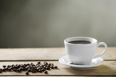 Fincan kahve ve kahve taneleri gri arka plan üzerinde ahşap tablo