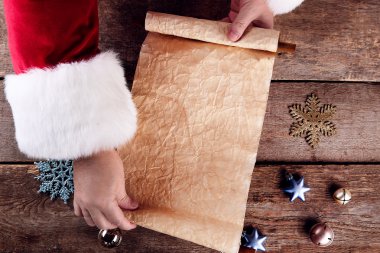 Noel Baba Noel dilek listesi üzerinde ahşap arka plan eller