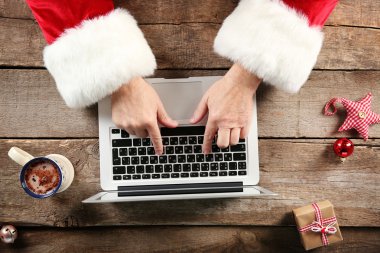 Noel Baba el ahşap masa üstünde laptop yazarak yakın çekim