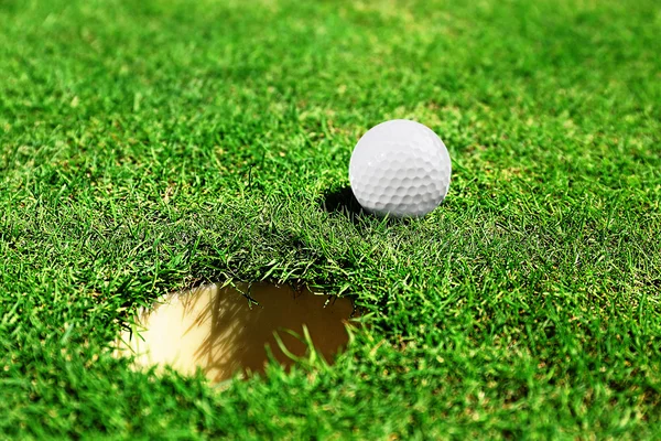 Pallina da golf sul labbro della tazza — Foto Stock