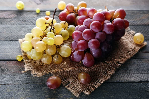 Uvas roxas suculentas, sobre fundo de madeira — Fotografia de Stock