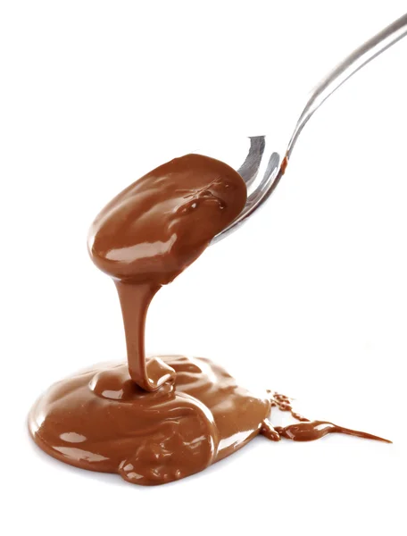 Melted milky brown chocolate pouring from a spoon, isolated on white — Stock Photo, Image