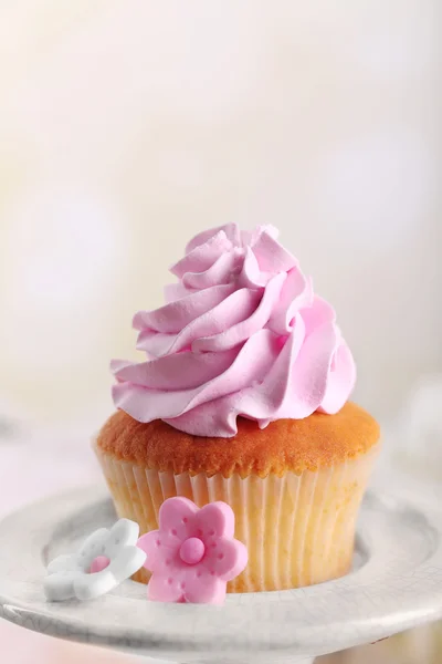 Tasty cupcake on stand, on light background — Stock Photo, Image