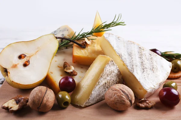 Diferentes tipos de queso con frutas y miel en la mesa, de cerca —  Fotos de Stock