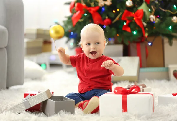 Baby met geschenkdozen en kerstboom — Stockfoto