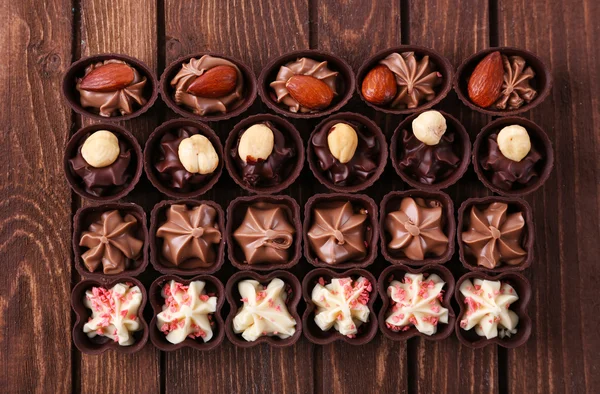 Doces de chocolate em fundo de madeira — Fotografia de Stock