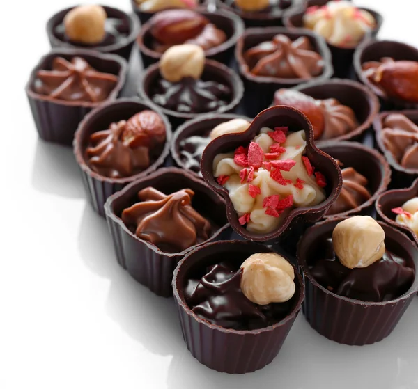 Deliciosos doces de chocolate no fundo branco, close-up — Fotografia de Stock