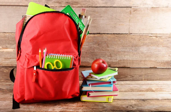 Mochila roja llena de papelería — Foto de Stock