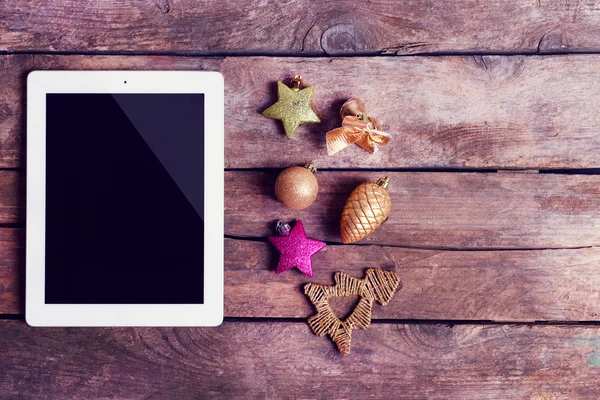 Tablet e decoração de Natal em fundo de madeira — Fotografia de Stock