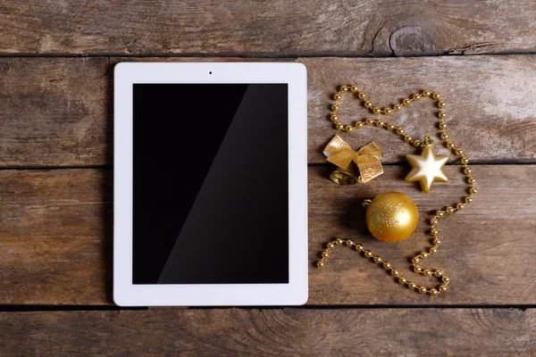 Tablet and Christmas decor on wooden background — Stock Photo, Image