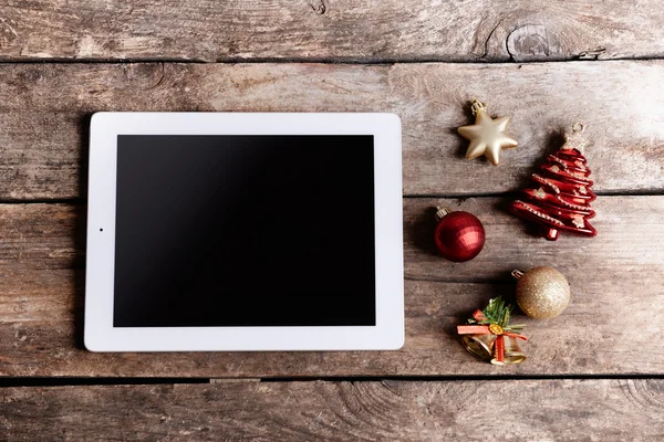 Tablet and Christmas decor on wooden background — Stock Photo, Image