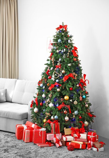Christmas fir tree with gifts in living room