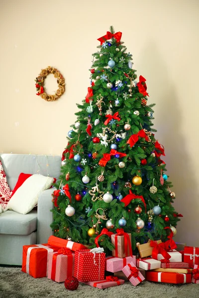 Christmas fir tree with gifts in living room — Stock Photo, Image