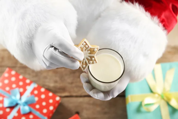 Weihnachtskonzept. Weihnachtsmann mit einem Glas Milch und Keksen in der Hand, aus nächster Nähe — Stockfoto