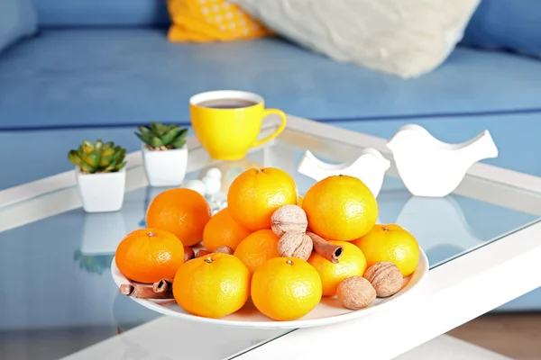 Assiette avec mandarines fraîches sur la table dans le salon, gros plan — Photo