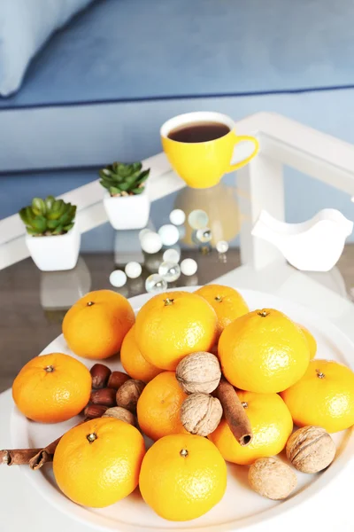 Placa com tangerinas frescas na mesa na sala de estar, close-up — Fotografia de Stock