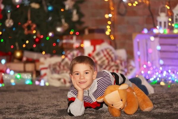 Jongen met teddybeer op een kerstfeest — Stockfoto