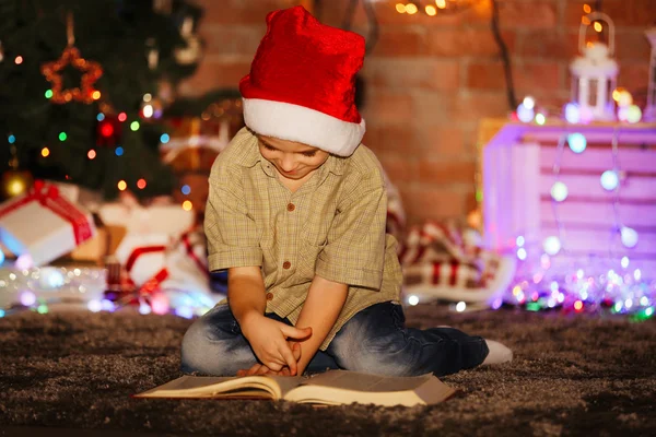 Liten pojke med boken sitter hemma — Stockfoto