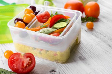 Lezzetli yemek plastik kaplarda ahşap masa yakın çekim