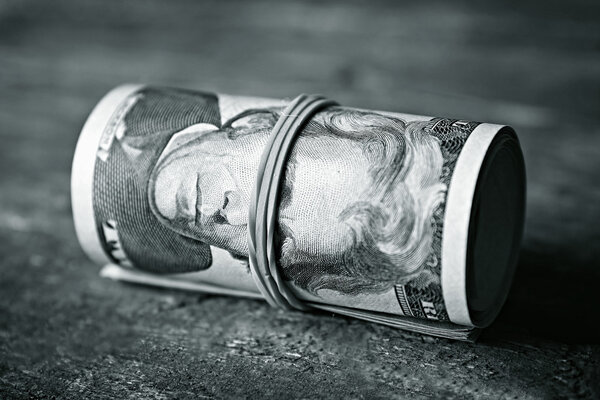 Dollars roll on wooden background