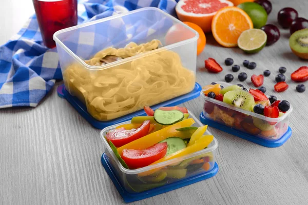 Leckeres Mittagessen in Plastikbehältern auf Holztisch aus nächster Nähe — Stockfoto