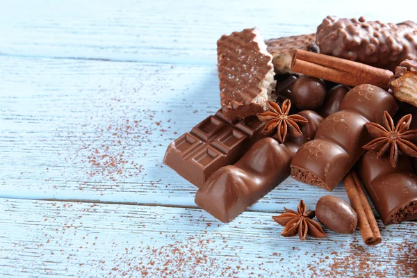 Doces de chocolate com pó sobre fundo de madeira — Fotografia de Stock