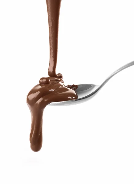 融化了从一个勺子，孤立在白色乳白色棕色巧克力浇注 — 图库照片