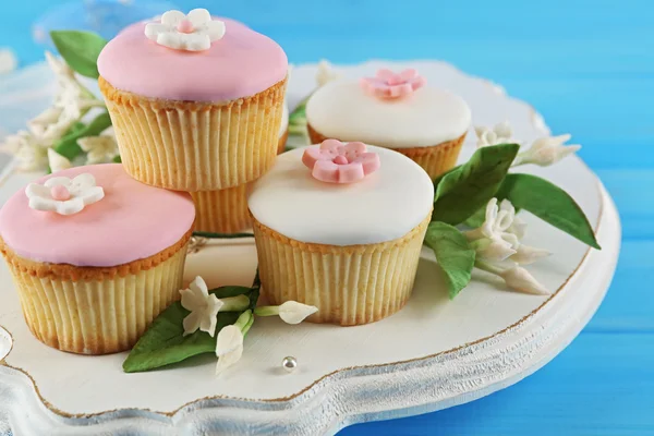 Tasty cupcakes on color wooden background — Stock Photo, Image