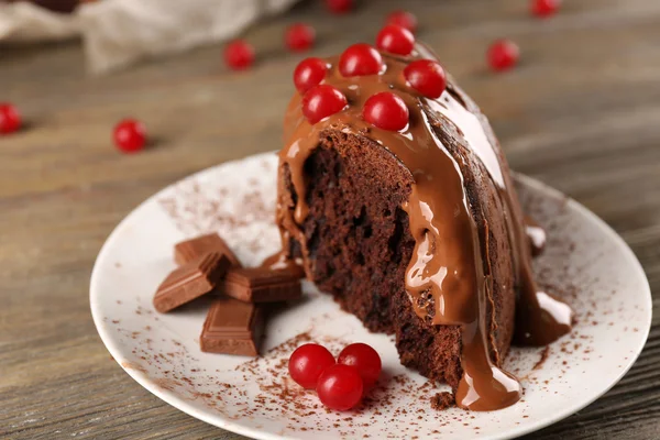 Pedazo de pastel de chocolate con bayas de árbol de nieve en una mesa — Foto de Stock