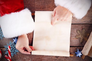 Noel Baba Noel dilek listesi üzerinde ahşap arka plan eller