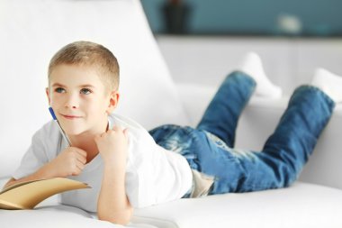 Defter ve kalem ile küçük çocuk