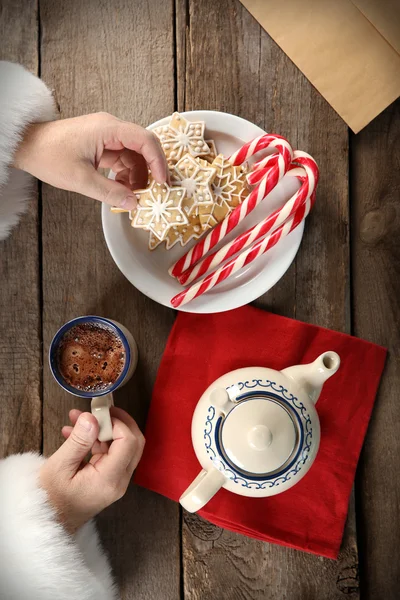 Christmas concept. Santa have a meal. Tasty cookies and cup of coffee on wooden background, close up — Stock Photo, Image