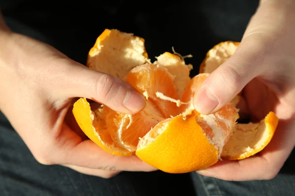 Woman hand peeling ripe sweet tangerine, close up — Stock Photo, Image