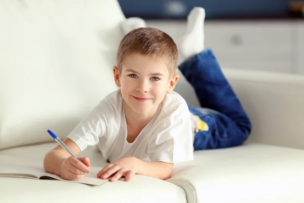 Menino com caderno e caneta — Fotografia de Stock