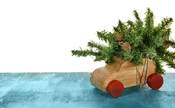 Carro de brinquedo de madeira com árvore de Natal em uma mesa sobre fundo branco — Fotografia de Stock