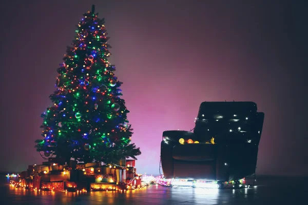 Árvore de Natal e poltrona em um quarto escuro — Fotografia de Stock
