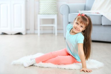 Halı üzerinde oturan kız