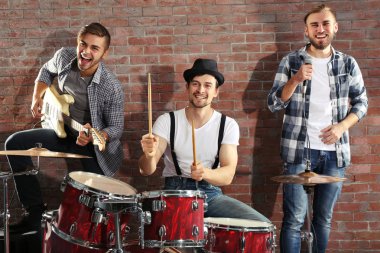 Bateri ve gitar çalmaya müzisyenler