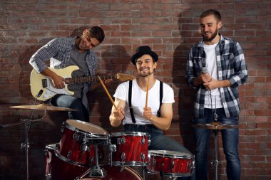 Bateri ve gitar çalmaya müzisyenler