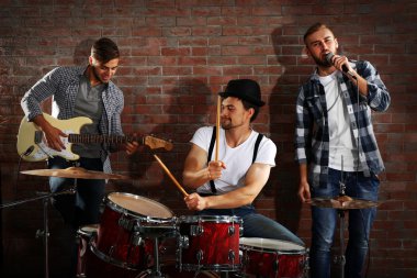 Bateri ve gitar çalmaya müzisyenler