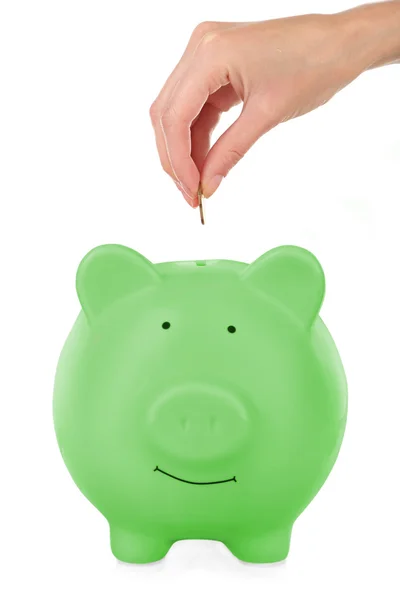 Female hand putting coin into piggy bank — Stock Photo, Image