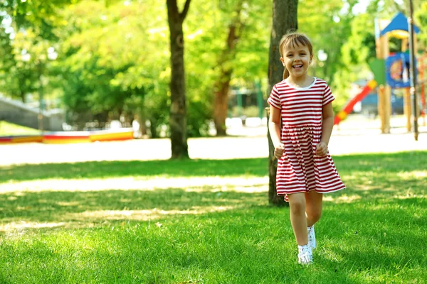 Kleines glückliches Mädchen spielt im Park — Stockfoto