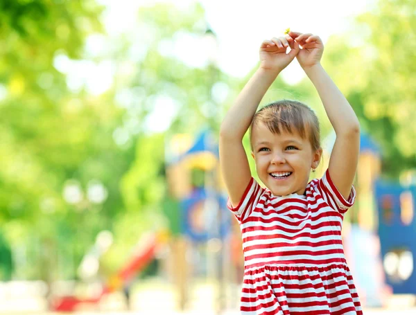 Little happy girl playing in park — Stock Photo, Image