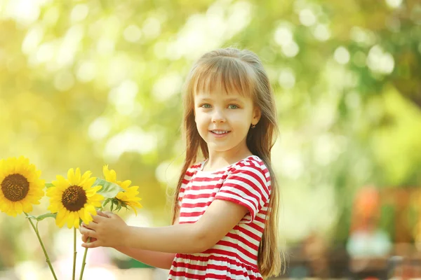 Kleines Mädchen mit Sonnenblumen — Stockfoto