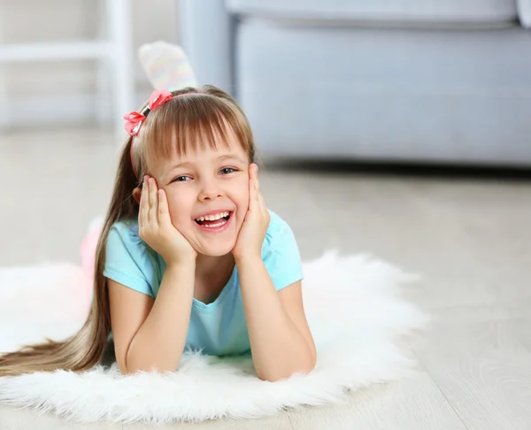 Lilla söta tjejen liggande på matta — Stockfoto